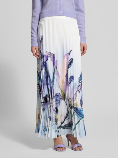 Kobiece model prezentuje spódnica plisowana 'Plisseerock mit Label-Detail und seitlichem Reißverschluss' od Marc Cain w linii a, długa spódnica, detal z logo, zapięcie na haftkę i wszyty zamek błyskawiczny z boku, nieprzezroczysta halka pod spódnicę, całkowita długość w rozmiarze 36: 100 cm, białe tło, pastelowe odcienie, kwiatowe wzory, widoczne faktury plisowania, Ganzkörperansicht von vorne.