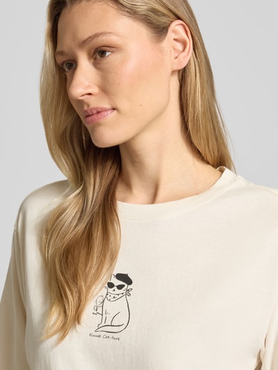 Kobiece modelka nosi damski t-shirt 'T-Shirt mit Rundhalsausschnitt und Motiv-Print' od Jake*s Casual z bawełny ekologicznej, prosty krój, okrągły dekolt, nadruk z motywem, długość tyłu w rozmiarze S: 62 cm, jasny kolor, gładka tekstura, zbliżenie na górną część ciała