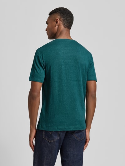 Mannenmodel draagt T-shirt uit mix van linnen en elastaan met ronde hals, regular fit, labeldetail van OLYMP Level Five, ruglengte maat M 69 cm, heren. Ganzlichaamsaanzicht achteraan.