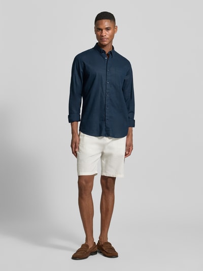 Męski model nosi Regular Fit Freizeithemd mit Leinen-Anteil von Matinique, mieszanka lnu i bawełny, kołnierzyk typu button down, listwa guzikowa, brustasza, długość tyłu w rozmiarze M: 64 cm, szerokość ramion w rozmiarze M: 43 cm, długość rękawów w rozmiarze M: 68 cm, ciemnoniebieski, gładki materiał, Ganzkörperansicht von vorne.