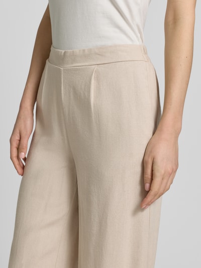 Frauenmodel trägt Regular Fit Culotte aus Viskose-Leinen-Mix Modell 'MYMILO' von Vero Moda in unifarbenem Beige mit teilelastischem Bund und seitlichen Eingrifftaschen, Material Flammgarn, Nahaufnahme Oberkörper.