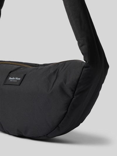 Produktfoto, schwarze Shoulder Bag mit Logo-Detail Modell 'Puffy' von Studio Noos, Reißverschluss, glatte Textur, rechteckige Form