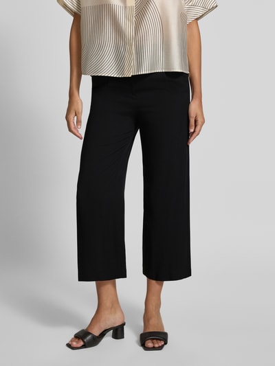 Frauenmodel trägt Culotte aus Viskose mit Gürtel von Christian Berg Woman, schwarze Wide Leg Fit Hose, Nahaufnahme Oberkörper und Beine.