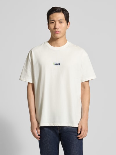 Męski model nosi t-shirt z logo-Print model 'Chase' od Les Deux z bawełny, prosty krój, okrągły dekolt, detal z logo, długość tyłu 72 cm w rozmiarze M, kolor jasny, gładka faktura, całkowity widok z przodu