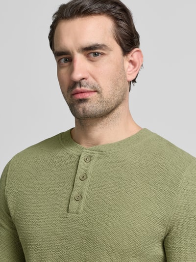 Männermodel trägt Regular Fit Longsleeve mit Knopfleiste von MCNEAL, strukturierte Oberfläche, elastischer Baumwoll-Mix, Nahaufnahme Oberkörper.