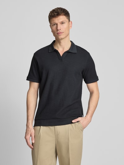 Męski model nosi Comfort Fit Poloshirt mit V-Ausschnitt von Lindbergh z bawełny, fakturowany wzór, detal z logo, długość tyłu 68 cm, Ganzkörperansicht von vorne.