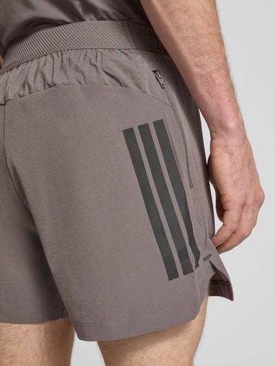 Mężczyznamodel nosi Regular Fit Sport-Shorts mit elastischem Bund von adidas Training, jednokolorowy, krój regular fit, nadruk z logo, wstawka z siateczki, elastyczny pas, boczne wpuszczane kieszenie, detailaufnahme