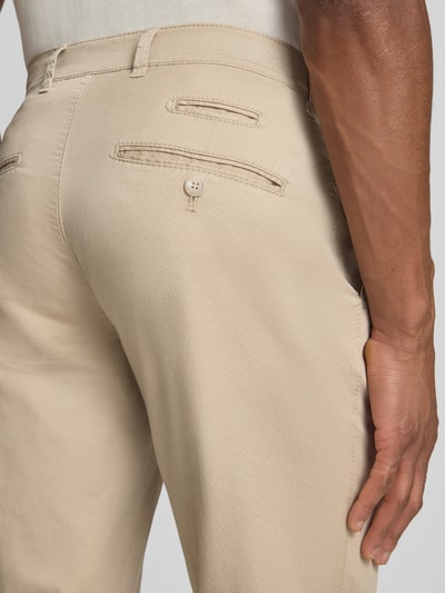 Männermodel trägt Fein strukturierte Hose Modell 'Fabio' von Brax, mieszanka bawełny i elastanu, krój slim fit, wpuszczane kieszenie, szerokość w rozmiarze 32/32: 42 cm, długość wewnętrzna nogawki 82 cm, jasnobeżowy kolor, fakturowana tkanina, detailaufnahme tyłu.
