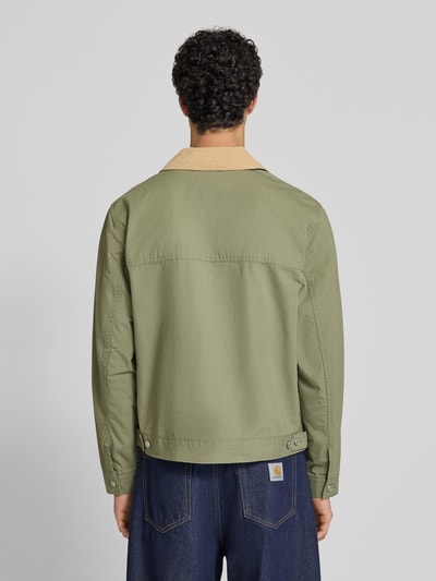 Męskimodel nosi Regular Fit Blouson aus reiner Baumwolle od Tommy Jeans, efekt: jednolity kolor, cieniowana przędza, wykładany kołnierz, zamek błyskawiczny, wyhaftowane logo, pas na plecach, patka, długi rękaw, mankiet, patka na dole, wpuszczane kieszenie, 100% bawełna, widok całej sylwetki z tyłu.