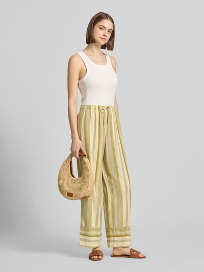 Kobiece model prezentuje spodnie z mieszanki lnu i wiskozy z elastycznym pasem model 'POLLY' od Topshop, paski, prosty krój, długość wewnętrzna nogawki 76 cm, szerokość w rozmiarze 36 to 34 cm, pełny widok przedni.