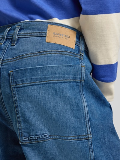 Frauenmodel trägt Barrel Fit Jeans mit Label-Detail Modell 'Sina' von Gang, blauer Baumwoll-Elasthan-Mix im Used-Look, Nahaufnahme Rückansicht.