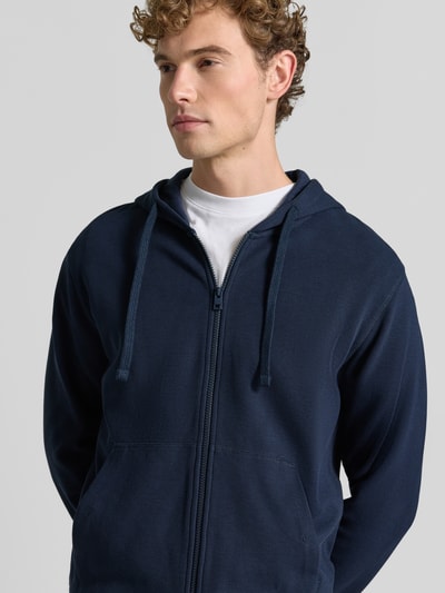Mężczyzna nosi Relaxed Fit Sweatjacke aus reiner Baumwolle von s.Oliver RED LABEL w kolorze granatowym, widok na górną część ciała z przodu.