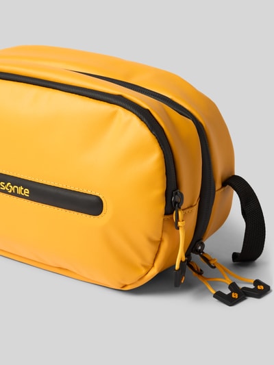Produktfoto, Kosmetiktasche mit Logo-Detail Modell 'Ecodiver' von Samsonite aus gelbem Material mit schwarzem Reißverschluss und geteiltem Hauptfach, Größe 25x17x9 cm, Innenfach mit Reißverschluss, glatte Struktur