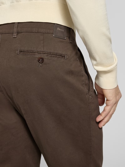 Männermodel trägt Straight Fit Stoffhose mit Lyocell-Anteil Modell 'Everest' von Brax in Dunkelbraun, Gesäßtasche, Detailaufnahme Rückansicht.