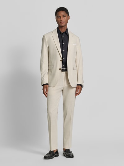 Männermodel trägt Anzughose mit Bügelfalten Modell 'Beppe' von CINQUE in Beige, Material-Mix mit Viskose-Anteil, Ganzkörperansicht von vorne.