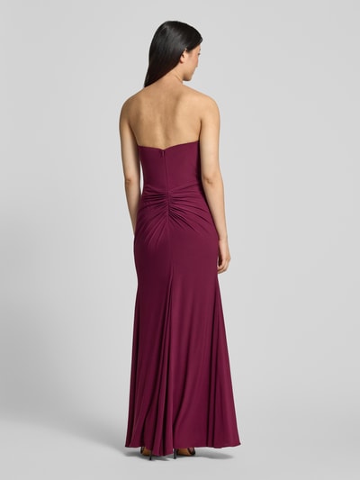 Frauenmodel trägt Slim Fit Abendkleid in Maxilänge mit Gehschlitz von Hey Kyla, Elastischer-Material-Mix, Raffung, Schulterfrei, Rückenlänge 132 cm, Brustweite 28 cm, einfarbiges, glattes Material, Ganzkörperansicht Rückansicht.