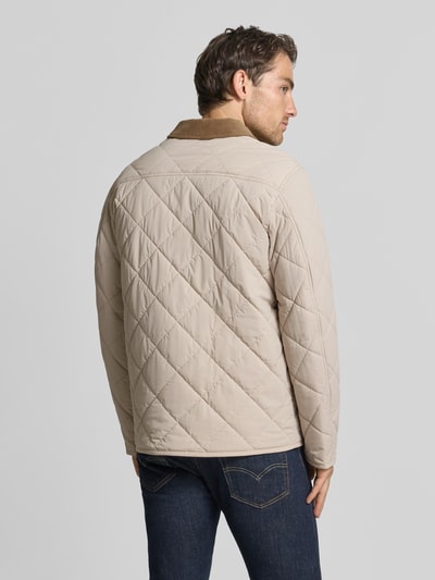 Mannenmodel draagt Steppjacke met Eingrifftaschen van CINQUE in beige, recht pasvorm, contrasterende platte kraag, opgestikte steekzakken, drukknoopsluiting, elastische materiaalmix, ruglengte maat M 76 cm, schouderbreedte 44 cm, borstwijdte 57 cm, mouwlengte 66 cm, geheel achteraanzicht.