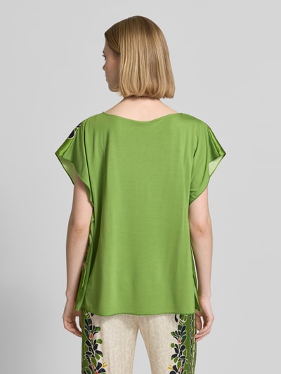 Frauenmodel trägt Bluse mit U-Boot-Ausschnitt von Marc Cain in Grün, gerader Schnitt, Micromodal-Mix, Ganzkörperansicht Rückansicht.