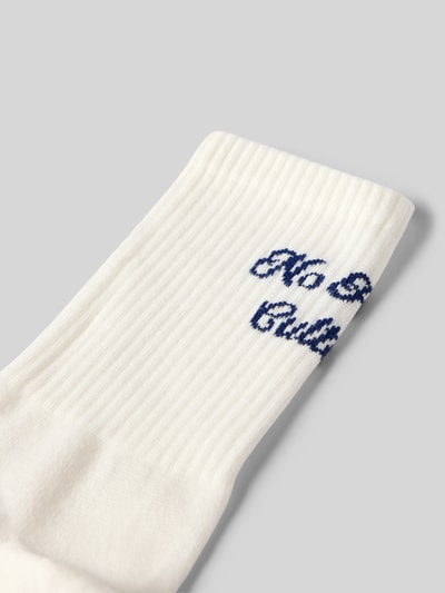 Produktfoto, cremefarbene Socken mit geripptem Bund und dunkelblauem Schriftzug, Modell 'No Hustle' von Karo Kauer, feine Struktur
