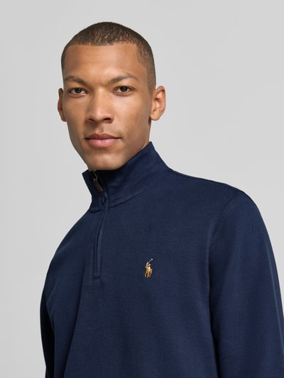 Männermodel trägt Relaxed Fit Troyer aus puur katoen von Polo Ralph Lauren in donkerblauw met fijne textuur, nahaufnahme oberkörper. Heren schipperstrui.
