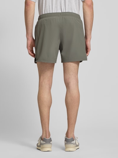 Männermodel trägt Shorts mit elastischem Bund von HALO in Olivgrün, Material-Mix mit Stretch, Regular Fit, Ganzkörperansicht Rückansicht.