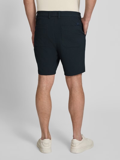 Männermodel trägt Regular Fit Bermudas mit Viskose-Anteil Modell 'KANE1' von BOSS in Melange-Optik, Rückansicht Ganzkörperansicht.