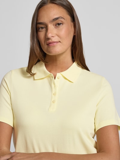 Frauenmodel trägt Regular Fit Poloshirt aus Baumwoll-Mix von s.Oliver RED LABEL in Hellgelb, unifarben, Piqué-Struktur, Nahaufnahme Oberkörper.
