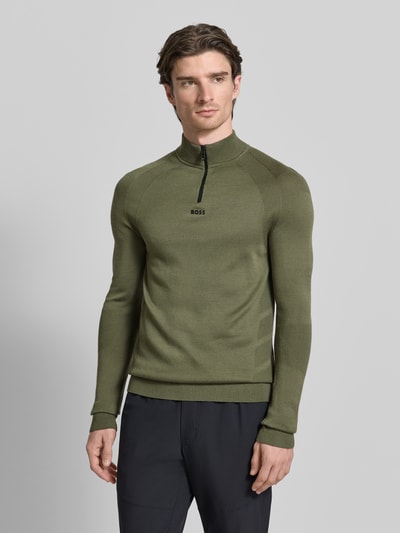 Männermodel trägt Regular Fit Troyer mit Schurwoll-Anteil Modell 'TOUR SEAMLESS QZ' von BOSS Green in Oliv, unifarben, Ganzkörperansicht von vorne.