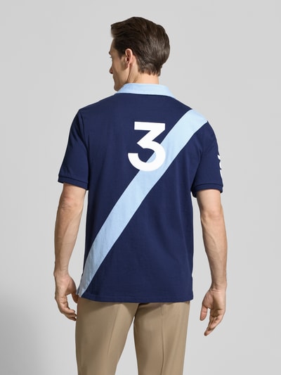 Männermodel trägt Regular Fit Poloshirt aus reiner Baumwolle von Polo Ralph Lauren in Two-Tone-Optik mit Logo-Stitching, Ganzkörperansicht Rückansicht.