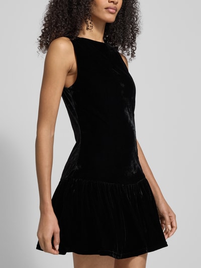 Frauenmodel trägt Minikleid mit U-Boot-Ausschnitt von Mango, schwarzer Material-Mix mit Stretch-Anteil, taillierter Schnitt, ausgestellte Rockpartie, Rückenlänge 83 cm, Brustweite 41 cm, Nahaufnahme Oberkörper.