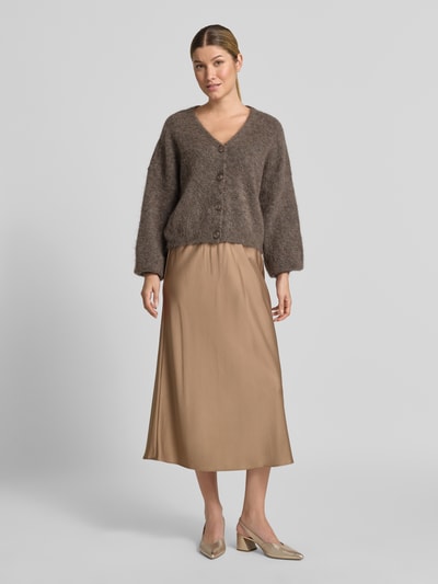 Frauenmodel trägt Midirock aus Satin mit elastischem Bund von Milano Italy in Beige, A-Linie, fließende Textur, Ganzkörperansicht von vorne. Bundweite bei Größe 36: 35 cm, Gesamtlänge bei Größe 36: 83 cm.