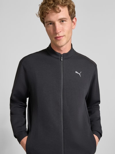 Männermodel trägt Sweatjacke mit Stehkragen und Reißverschluss Modell 'CLOUDSPUN' von PUMA PERFORMANCE, Lyocell-Material-Mix, Logo, Regular Fit, Nahaufnahme Oberkörper.