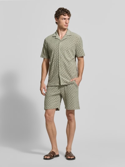 Männermodel trägt Regular Fit Shorts mit Label-Patch von Lindbergh aus Baumwoll-Mix mit Eingrifftaschen und Gesäßtasche, Ganzkörperansicht von vorne.