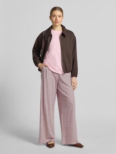 Frauenmodel trägt Wide Leg Sweatpants aus Lyocell-Mix Modell 'ANNI' von VILLA SOPHIE mit Optik: Allover-Muster, Passform: Wide Leg, Label-Patch, Bundabschluss: elastisch, Materialverarbeitung: Jersey, Material: Lyocell-Mix, rosafarbene und braune Streifen, fließende Struktur, Ganzkörperansicht von vorne.