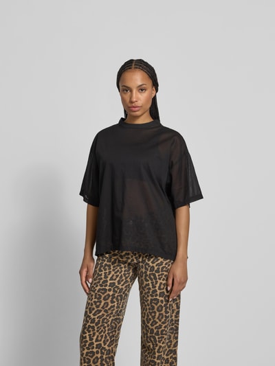 Frauenmodel trägt T-Shirt in semitransparenter Optik von black palms aus Reine Baumwolle, Lockerer-Schnitt, Rundhalsausschnitt, Überschnittene-Ärmel, Rückenlänge 66 cm bei Größe S, schwarze Farbe, glatte Textur, Ganzkörperansicht von vorne.