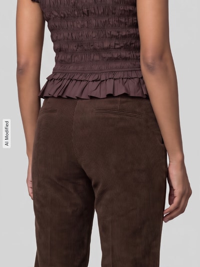 Kobieta nosi spodnie sztruksowe Regular Fit Cordhose mit angedeuteten Taschen Modell 'AMELIE' od CAMBIO w brązowym kolorze, widok tyłem, zdjęcie szczegółowe, obraz zmodyfikowany przez AI, KI-modifiziertes Bild.