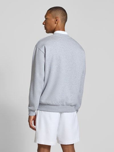 Männermodel trägt Regular Fit Sweatshirt aus Baumwoll-Mix von Lacoste in Hellgrau, weiße Shorts, glatte Textur, Ganzkörperansicht Rückansicht.
