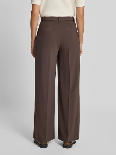Frauenmodel trägt Wide Fit Hose mit Bundfalten von Rich & Royal in Braun, glatte Textur, Gesäßtaschen, Ganzkörperansicht Rückansicht.
