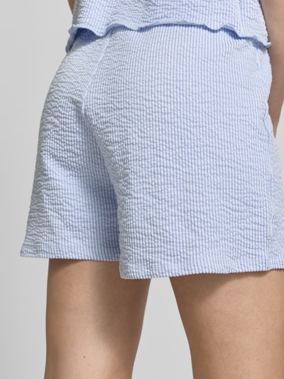 Frauenmodel trägt Regular Fit Shorts aus Baumwoll-Mix Modell 'MISTY' von Only mit Allover-Muster, gestreift, Seersucker Materialverarbeitung, Nahaufnahme Rückansicht.
