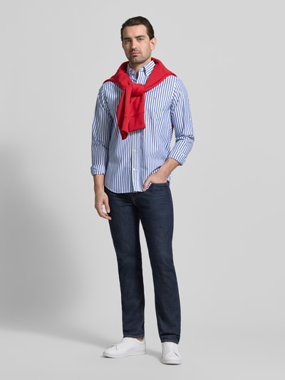 Männermodel trägt Slim Fit Freizeithemd mit Brusttasche von Gant, blau-weiß gestreift, reine Baumwolle, Ganzkörperansicht von vorne.