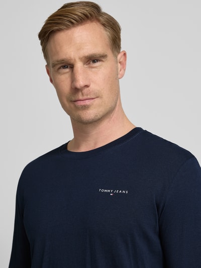 Männermodel draagt Slim Fit Langarmshirt uit puur katoen van Tommy Jeans, look: effen, labelopschrift, ronde hals, lange mouwen, Nahaufnahme bovenlichaam.