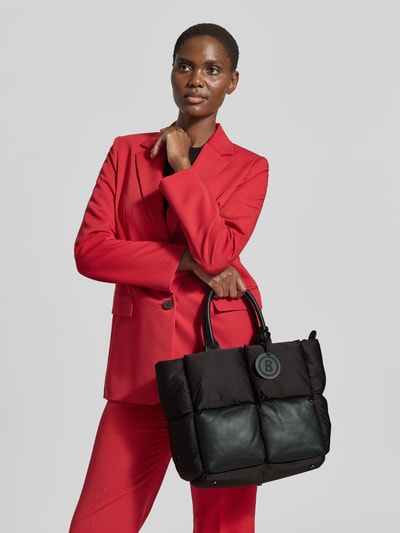 Frauenmodel trägt Shopper mit Steppnähten Modell 'gletsch amelie' von BOGNER in Schwarz, Ganzkörperansicht von vorne. Damen Shopper mit Reißverschluss, Steppnähten, Tragehenkeln, Schulterriemen, Label-Detail; Breite 42 cm, Länge 30 cm, Tiefe 17 cm, Länge Schulterriemen 40 cm.