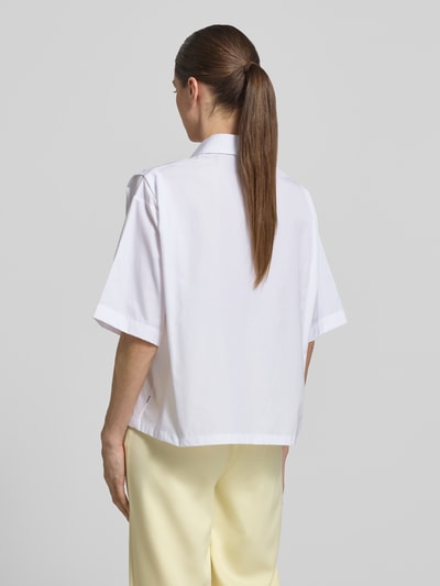 Frauenmodel trägt Oversized Hemdbluse aus reiner Baumwolle Modell 'BIMINA' von BOSS in Weiß, kurze Ärmel, Popeline, Rückansicht Ganzkörperansicht.