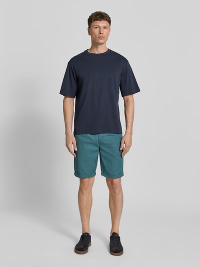Männermodel trägt Chino Shorts mit Gesäßleistentaschen von Lerros in Türkis, Baumwoll-Mix, Straight Fit, Ganzkörperansicht von vorne.