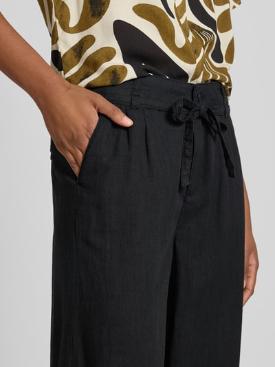Frauenmodel trägt Wide Fit Stoffhose mit Bügelfalten Modell 'Livia' von Angels aus Reine Baumwolle mit Eingriffstaschen, Nahaufnahme Oberkörper.