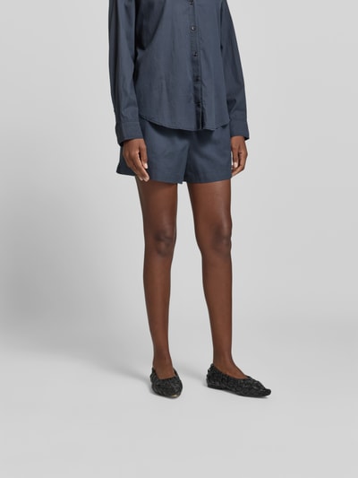 Frauenmodel trägt Shorts mit Lyocell-Anteil von Juvia im Baumwoll-Lyocell-Mix, Dunkelblau, elastischer Bund, Gesäßtaschen, Ganzkörperansicht von vorne.