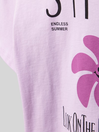 Mädchen trägt Kinder T-Shirt von Only, Modell 'SUN-VERAS' mit Optik: Unifarben, Motiv-Print, Jersey aus reiner Baumwolle, Detailaufnahme.