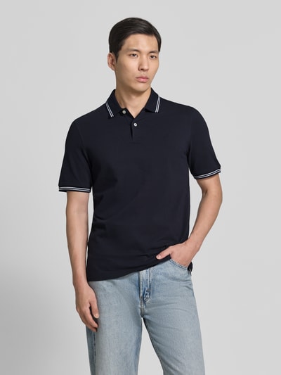 Männermodel trägt Regular Fit Poloshirt mit Logo-Stitching von bugatti in Dunkelblau aus Reine Baumwolle, Ganzkörperansicht von vorne. Rückenlänge bei Größe M: 71 cm, Polokragen, kurze Knopfleiste, Label-Detail.