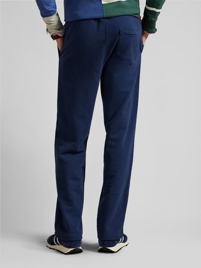 Männermodel trägt Regular Fit Sweatpants aus reiner Baumwolle von Polo Ralph Lauren, unifarbenes Dunkelblau, Gesäßtasche, Ganzkörperansicht Rückansicht.