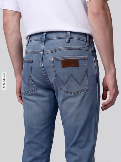 Männermodel trägt hellblaue Straight Fit Jeans aus Baumwoll-Mix Modell 'Greensboro' von Wrangler, Herrenjeans, Ganzkörperansicht Rückansicht, KI-modifiziertes Bild.